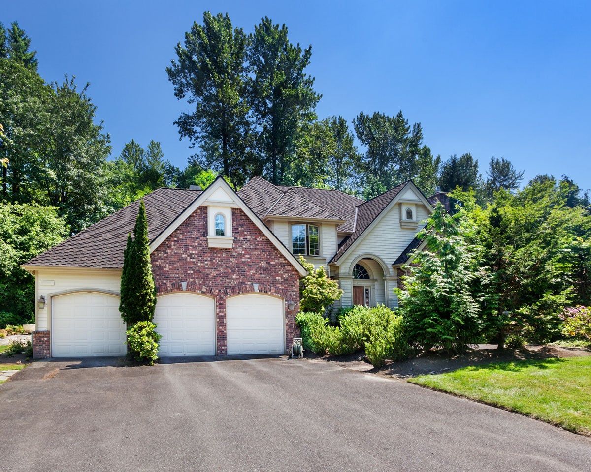 house with 3 car garage surrounded by pruned trees