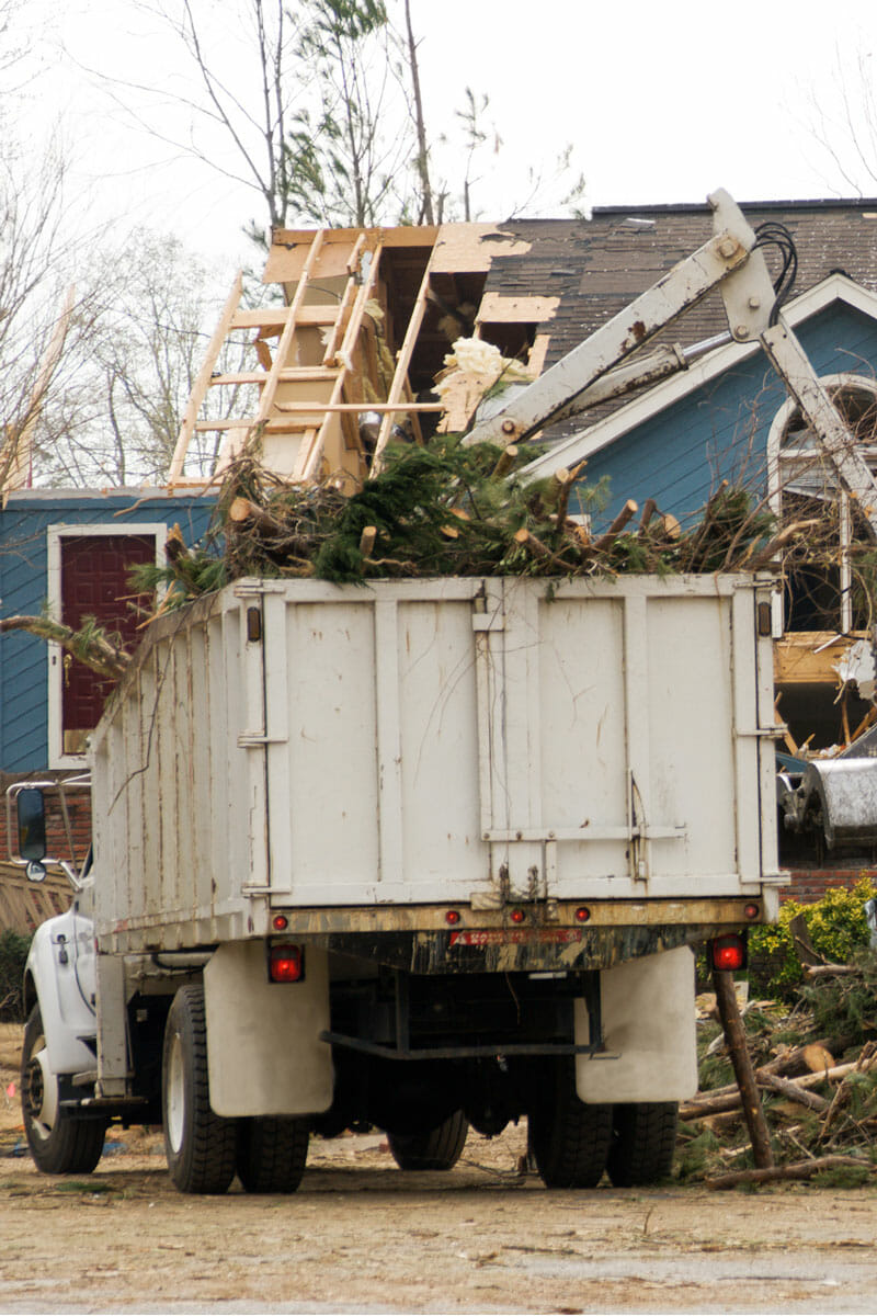 Seattle Arborist team loads tree cuttings into dump truck after storm damage